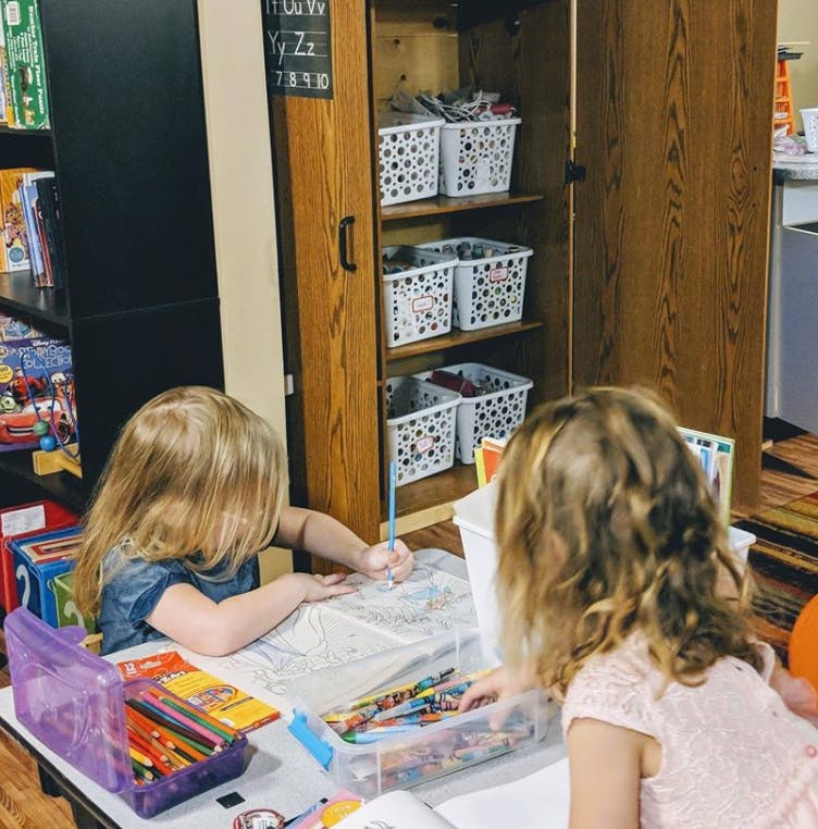Two children drawing at a table