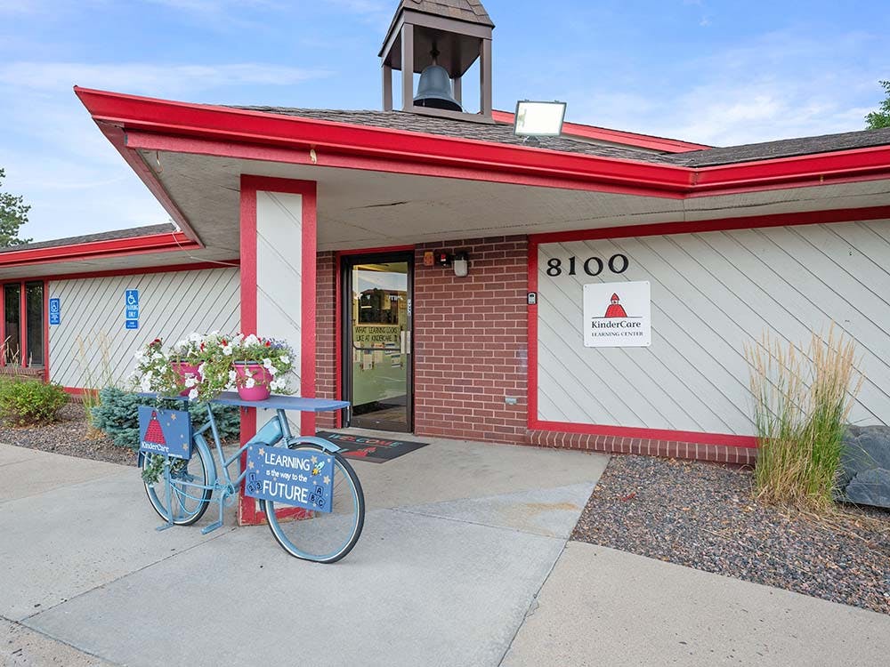 Entrance to a KinderCare Learning Center with a decorative bicycle