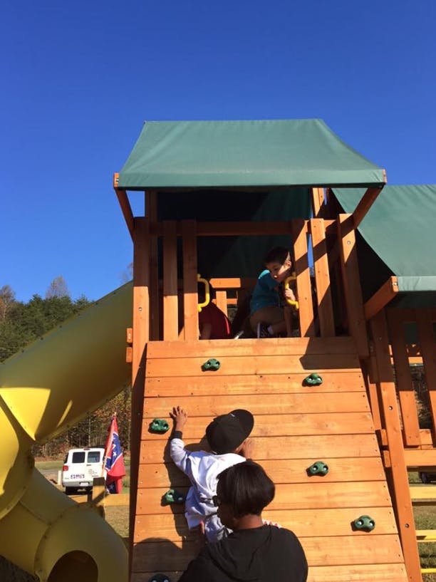 Children climbing on a wooden playground structure