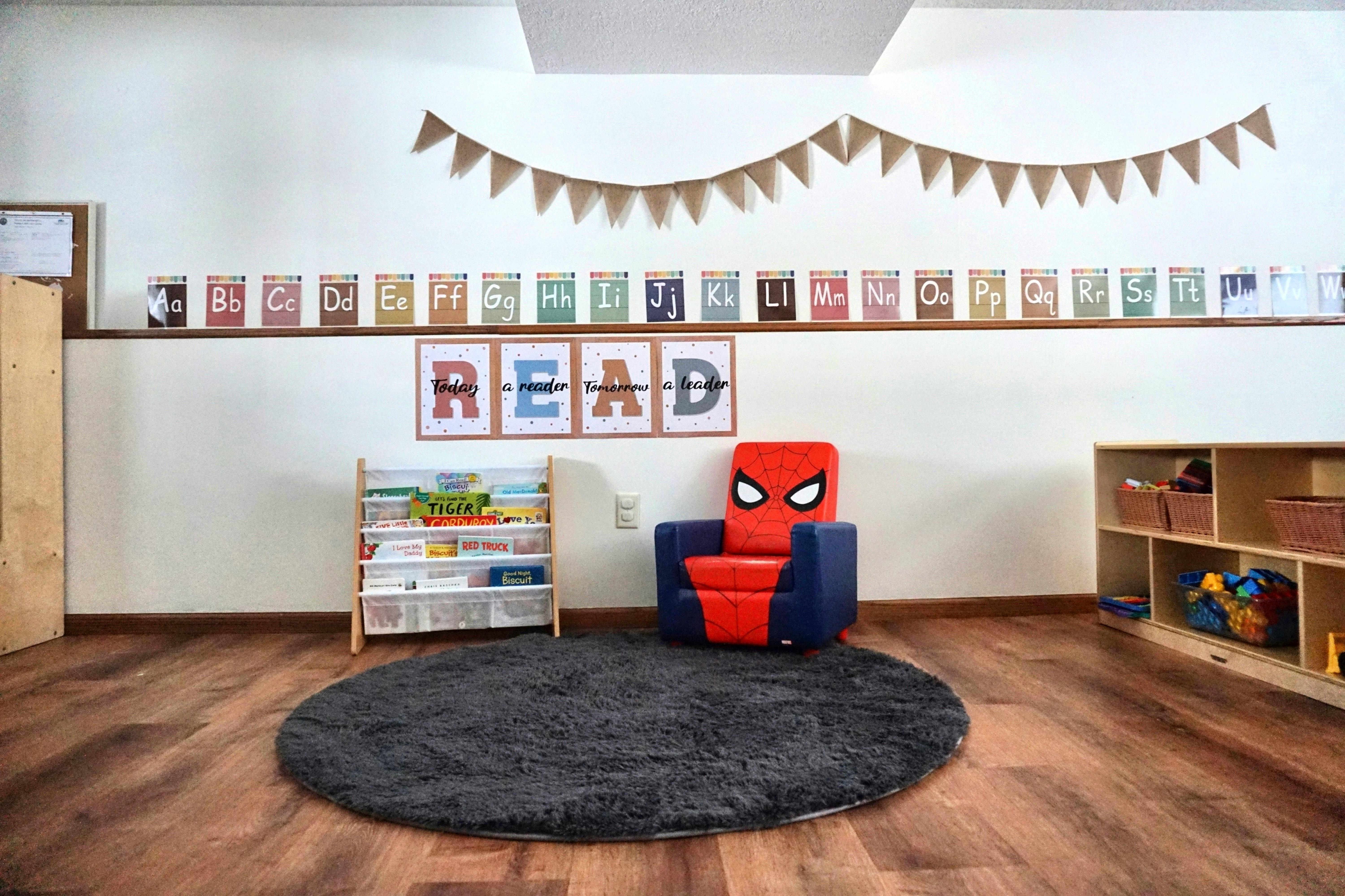 reading nook with a Spiderman chair, bookshelf, and 'READ' sign