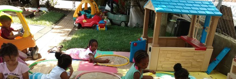 Children playing in a sandbox and on a toy car