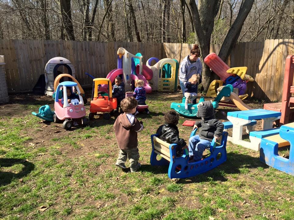 Children and an adult playing on outdoor playground equipment