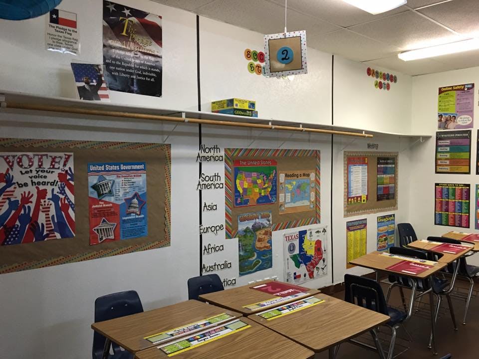Classroom with student desks and educational posters on the walls