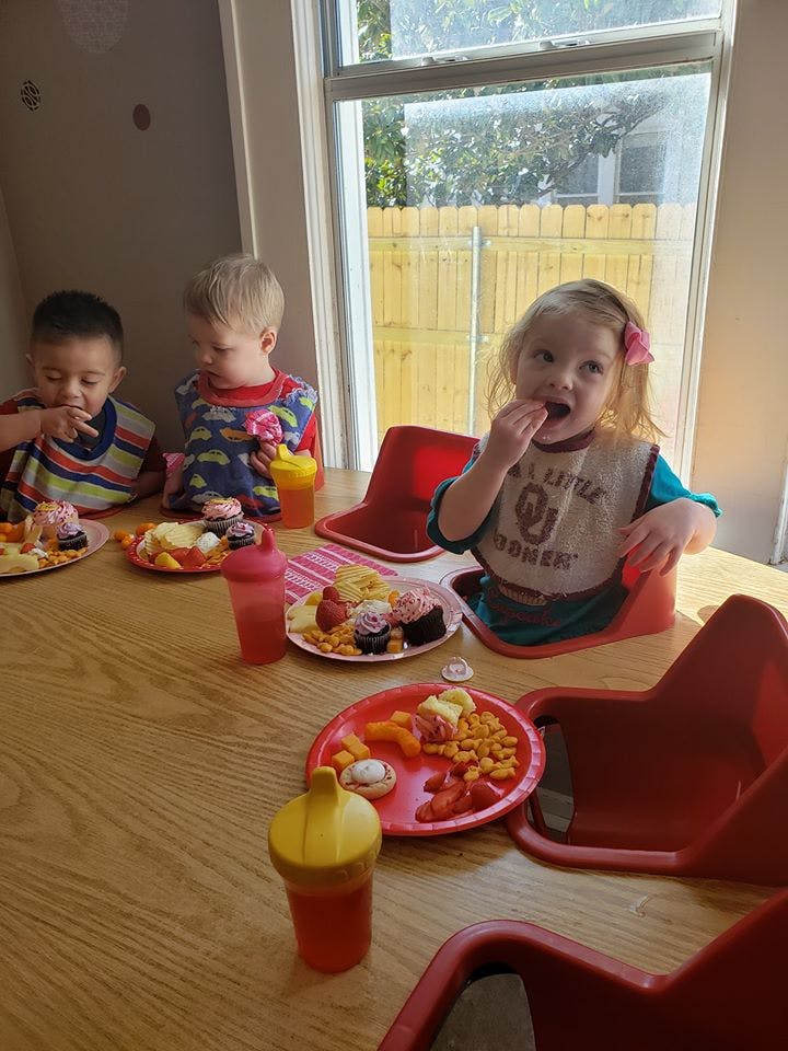 Three children eating snacks at a table
