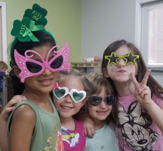 Four children wearing novelty sunglasses