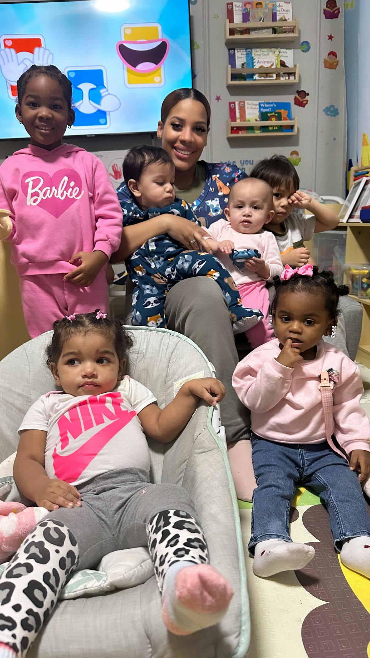 Person with multiple children and babies in a room