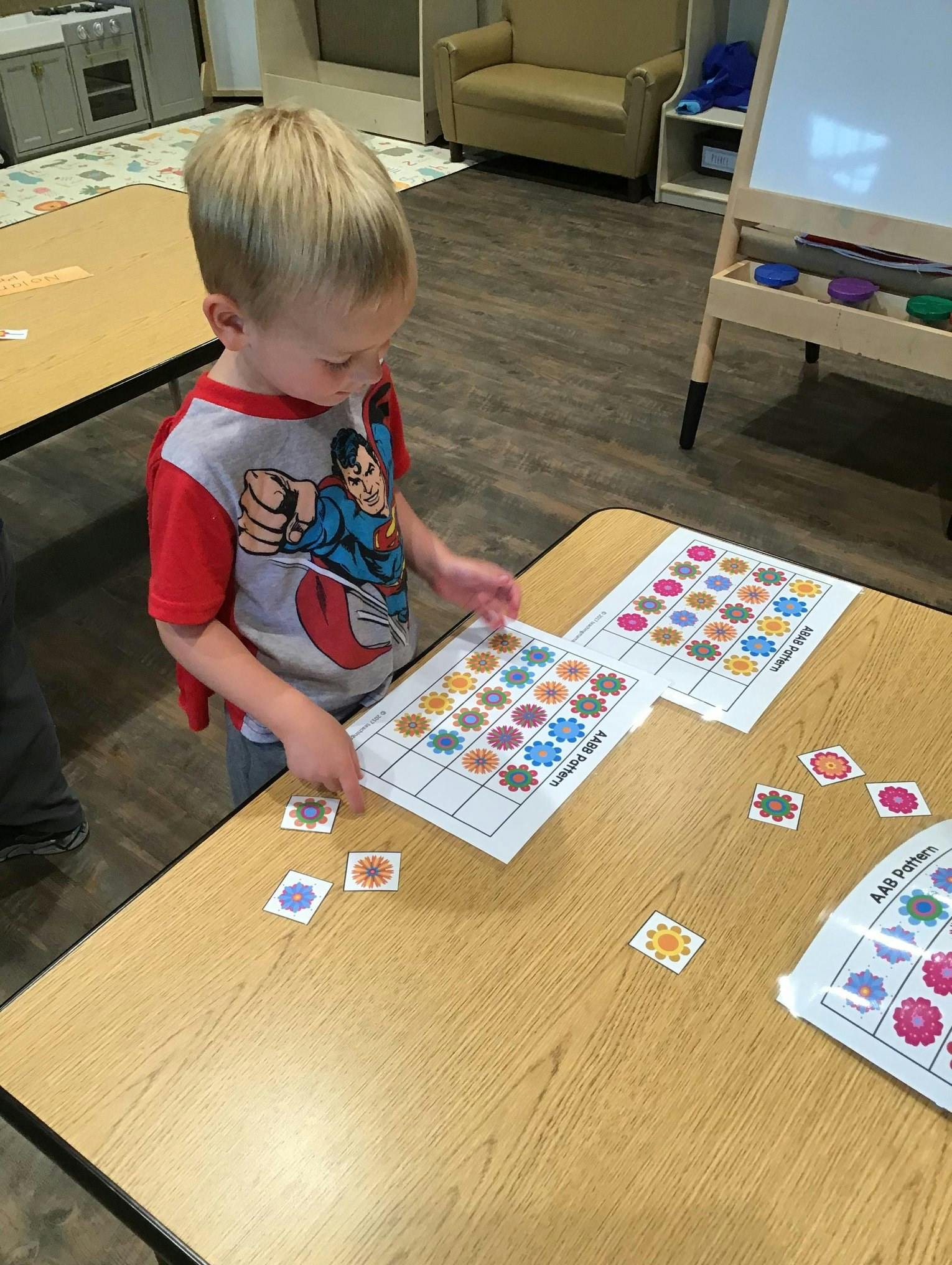 Child playing with pattern matching cards on a table