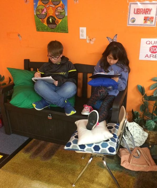 Two children sitting and reading in a classroom