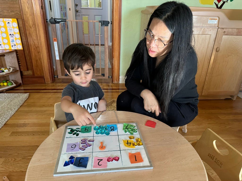 Adult and child playing a board game at a table
