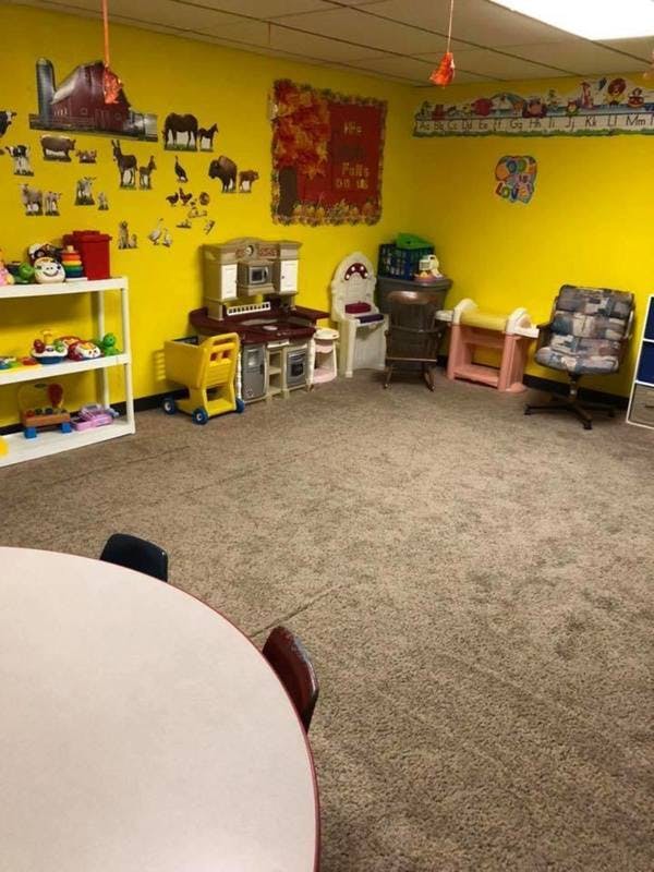 Playroom with yellow walls, toys, and a play kitchen