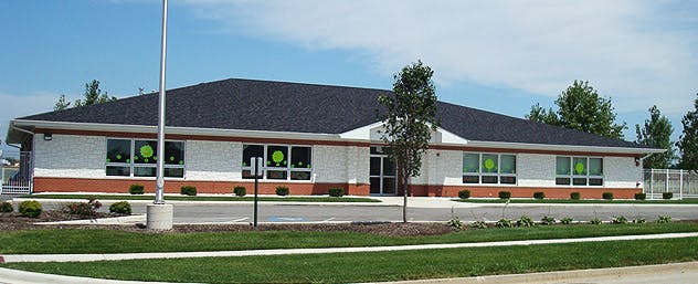 Exterior of a single-story building with a dark roof and white walls