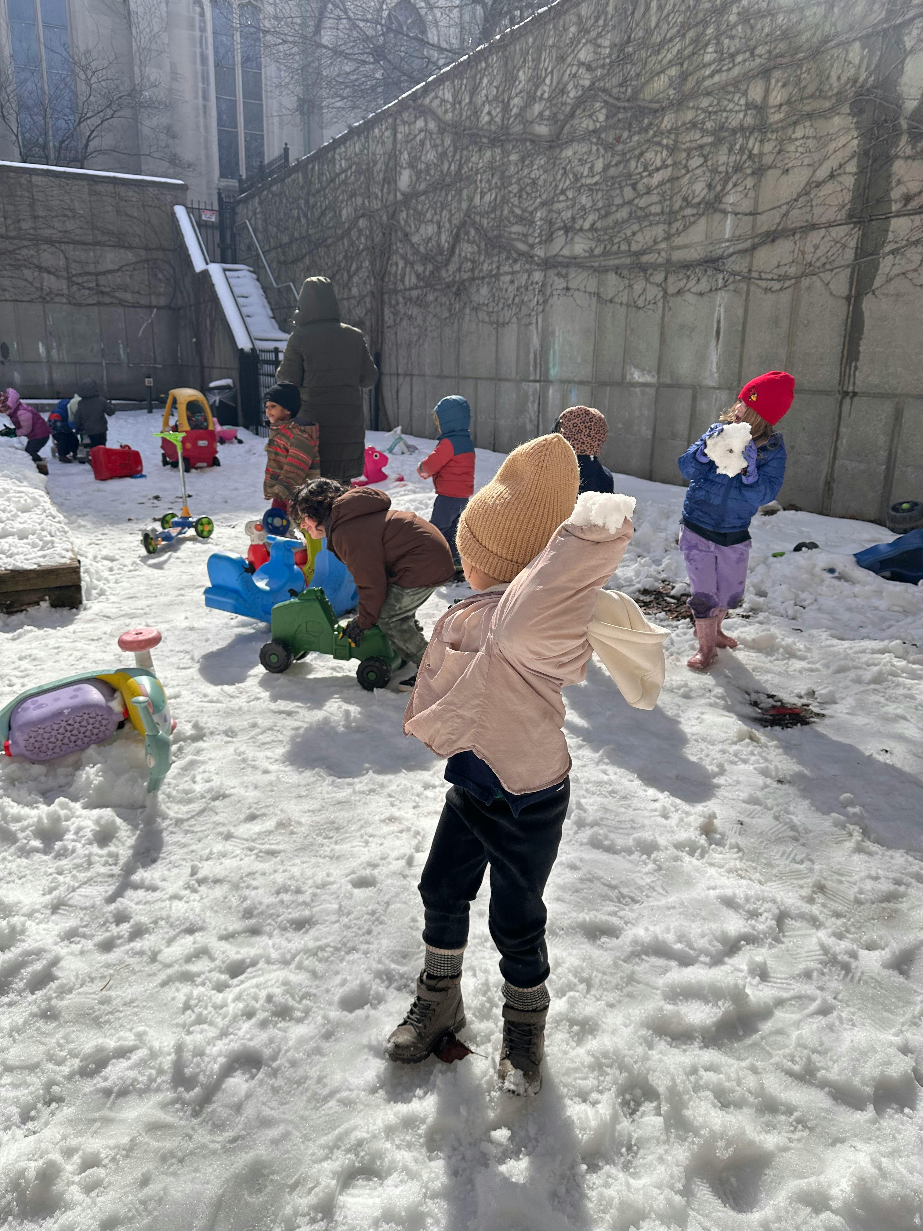 Children playing in the snow with toys
