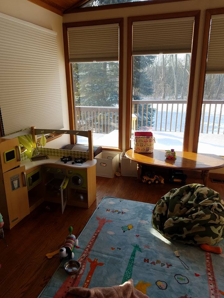 Play kitchen and rug in a room with large windows overlooking a snowy landscape