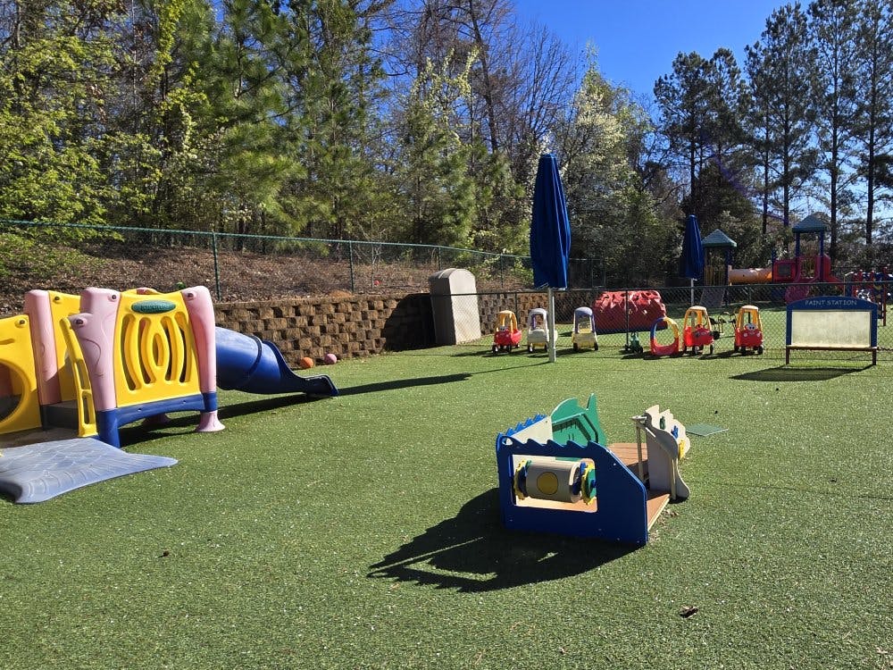 Children's playground with colorful slides, climbing structures, and ride-on toys