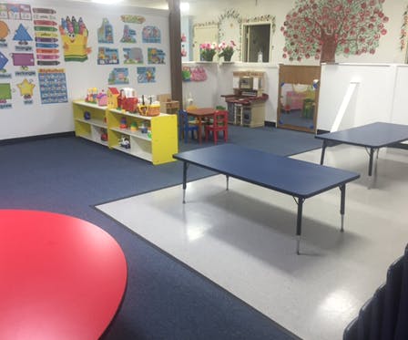 Empty classroom with blue tables and yellow shelves