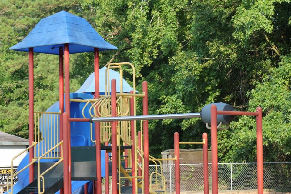 Playground structure with slides and climbing bars