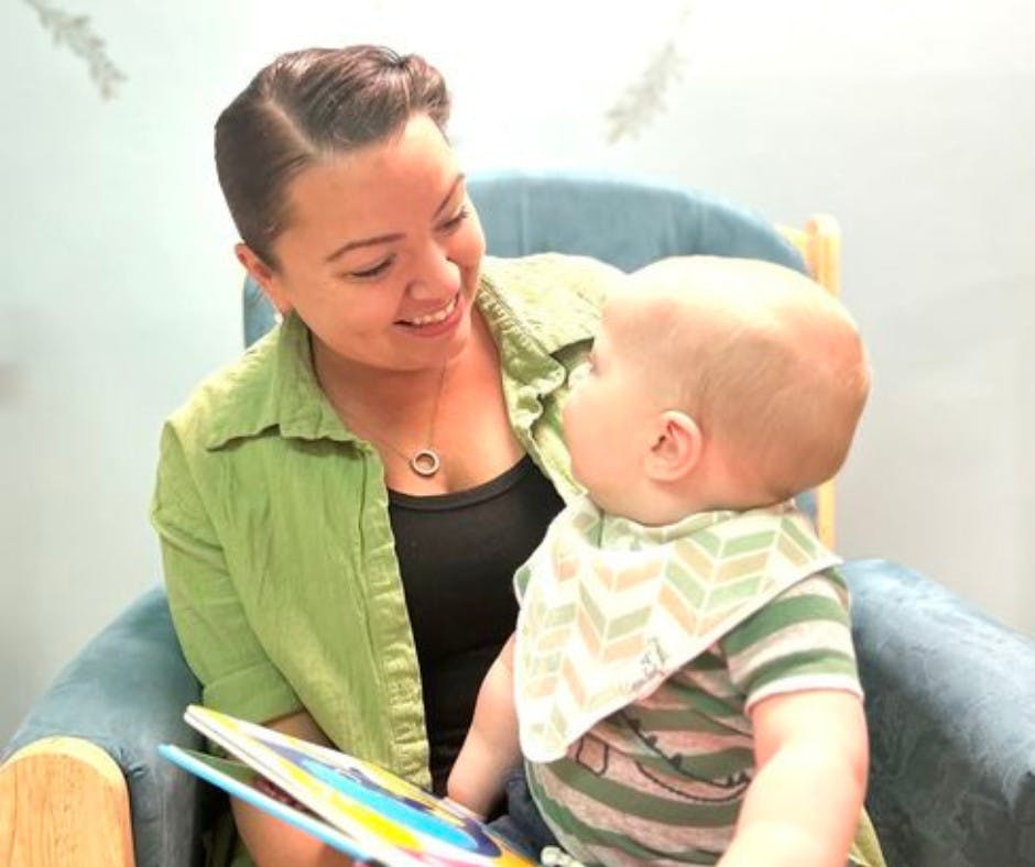 Person holding a book and looking at a child