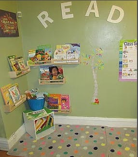 Books on shelves in a room with "READ" on the wall