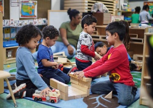 Children playing with wooden blocks and toys in a classroom