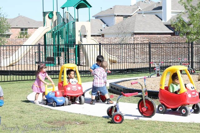 Children playing with ride-on toys on a playground