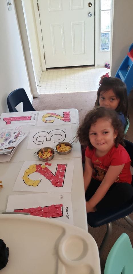 Two children at a table with number crafts and letter crafts