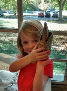 Child holding a clay sculpture