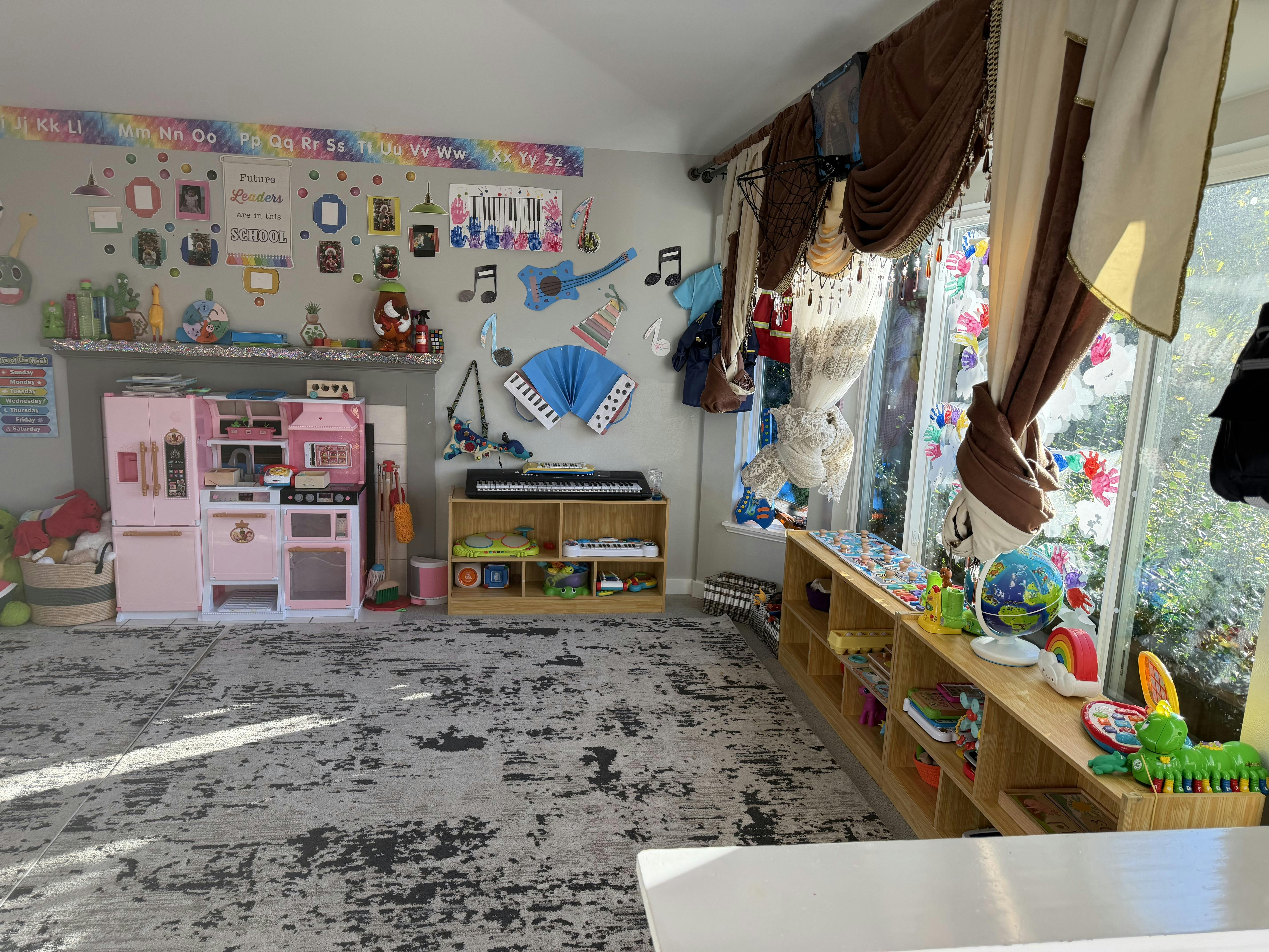 Playroom with a play kitchen and shelves filled with educational children toys