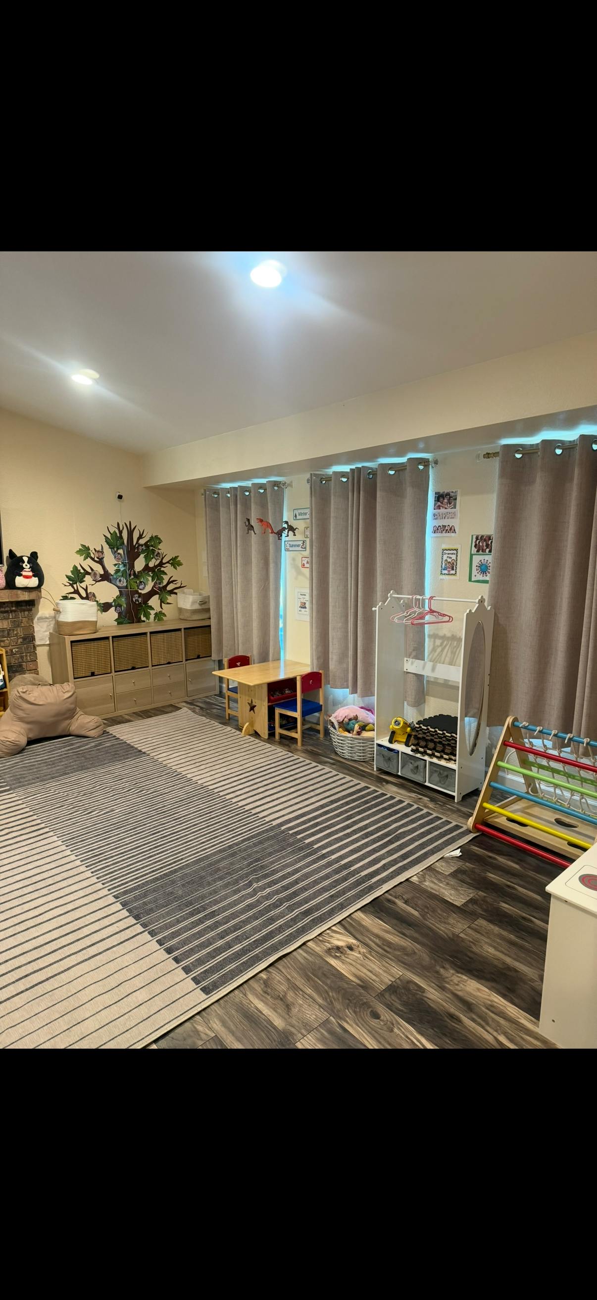 Playroom with a small table, storage shelves, and a rug
