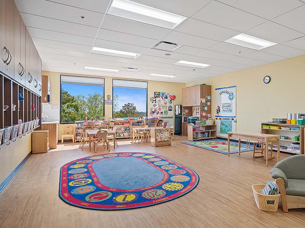 Empty colorful preschool classroom with small tables and chairs