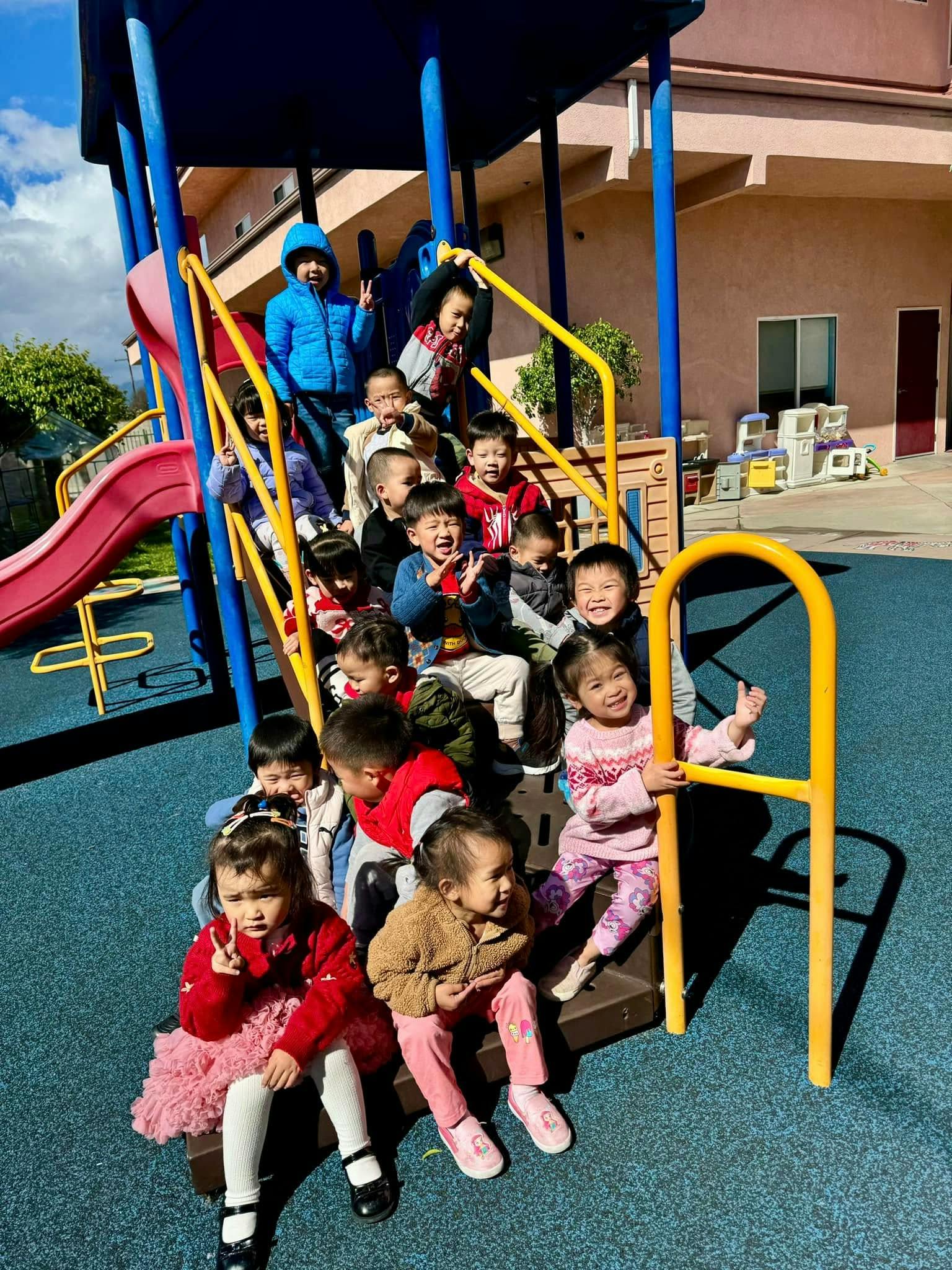Many children on and around a playground structure