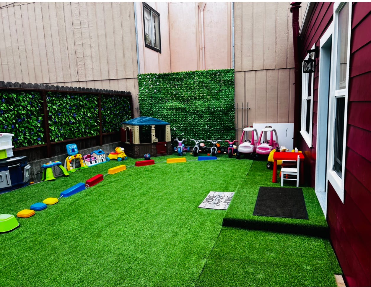 Outdoor play area with artificial turf and various toys