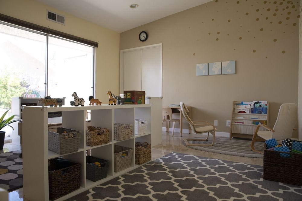 Playroom with storage cubbies, animal toys, chairs, and patterned rugs