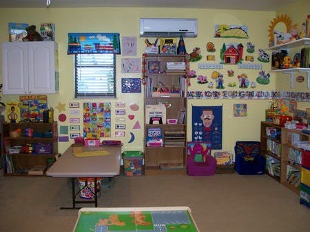 Classroom with a table, shelves, and decorations on the walls