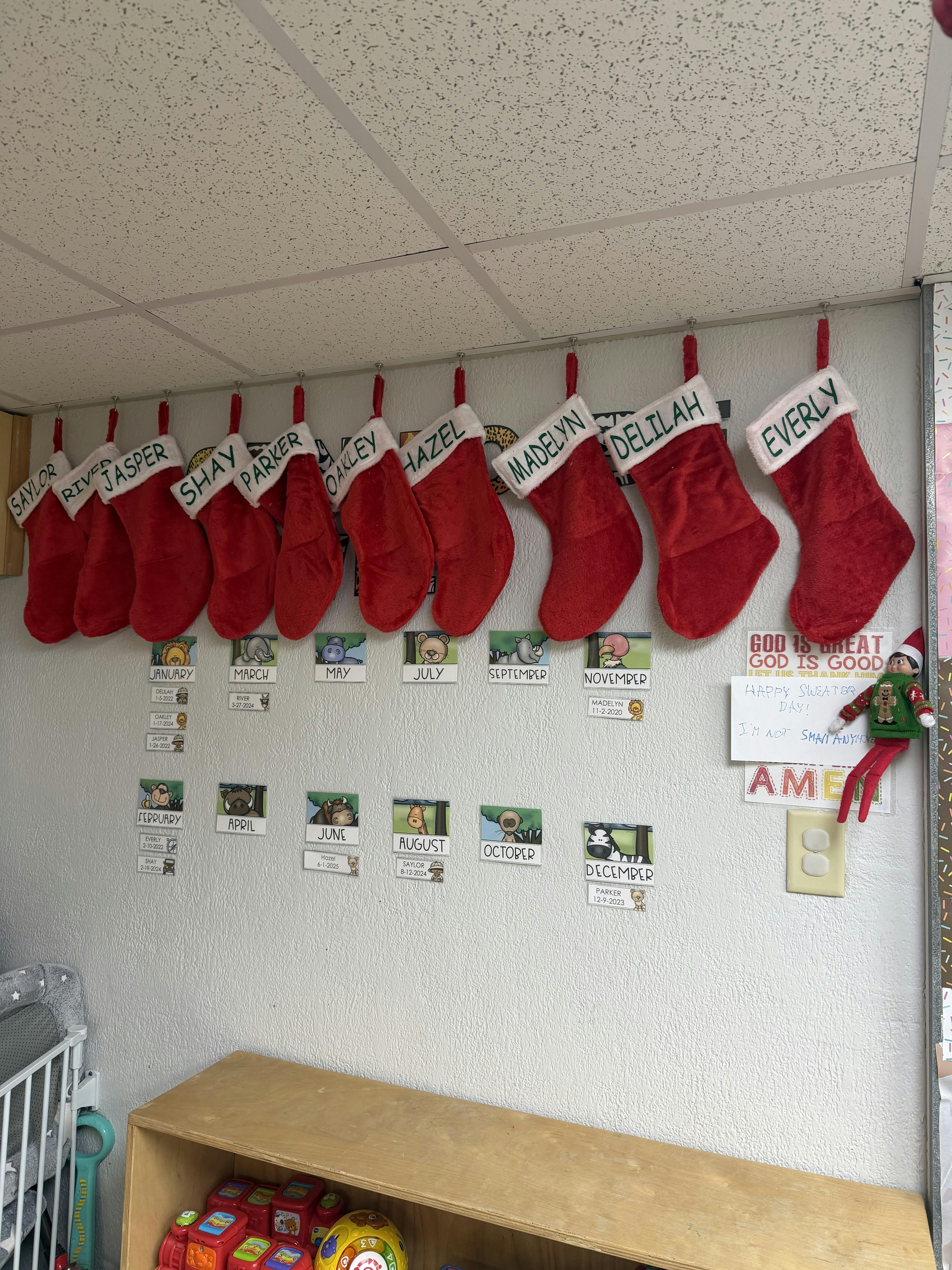 Red personalized Christmas stockings hanging on a wall above birthday cards