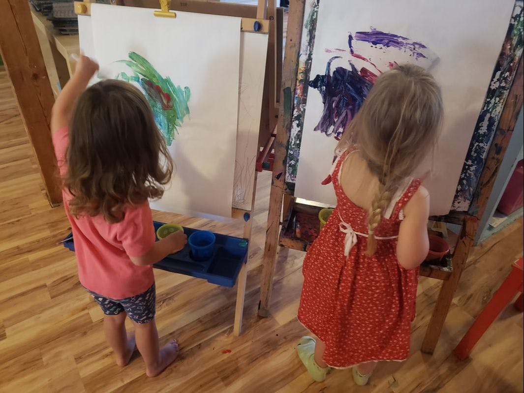 Two children painting at easels