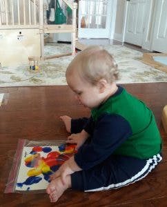 Child playing with colorful shapes on the floor