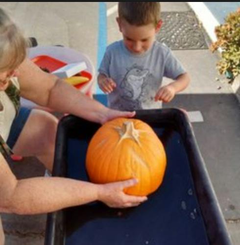 Person and child with a pumpkin