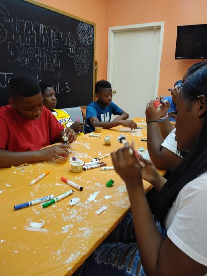 Children and teens at a table doing crafts