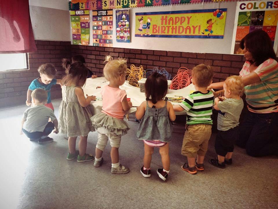 Adult and multiple children gathered around a table