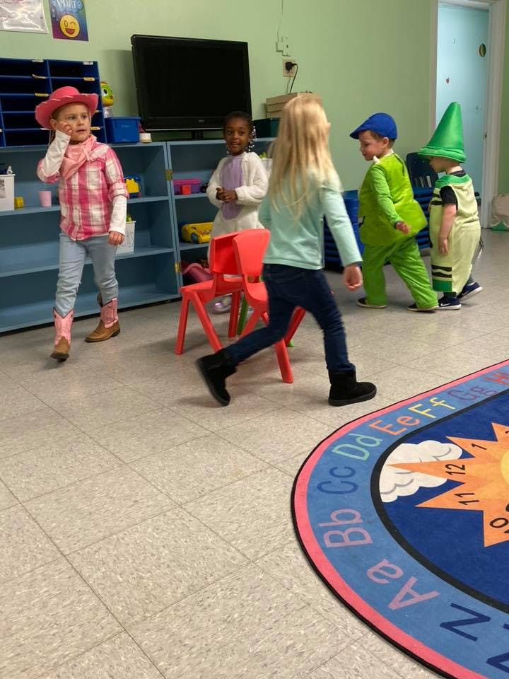 Children in costumes playing in a classroom