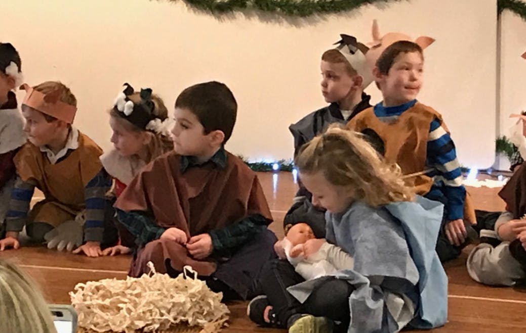 Children in costumes sitting on a floor