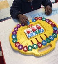 Child playing with a yellow alphabet toy