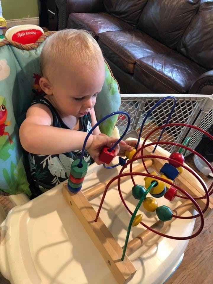 Child playing with a bead maze toy