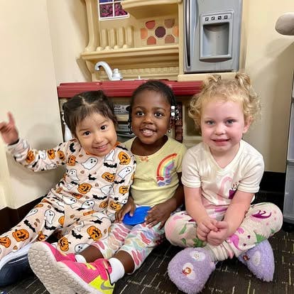 Three children sitting together on the floor