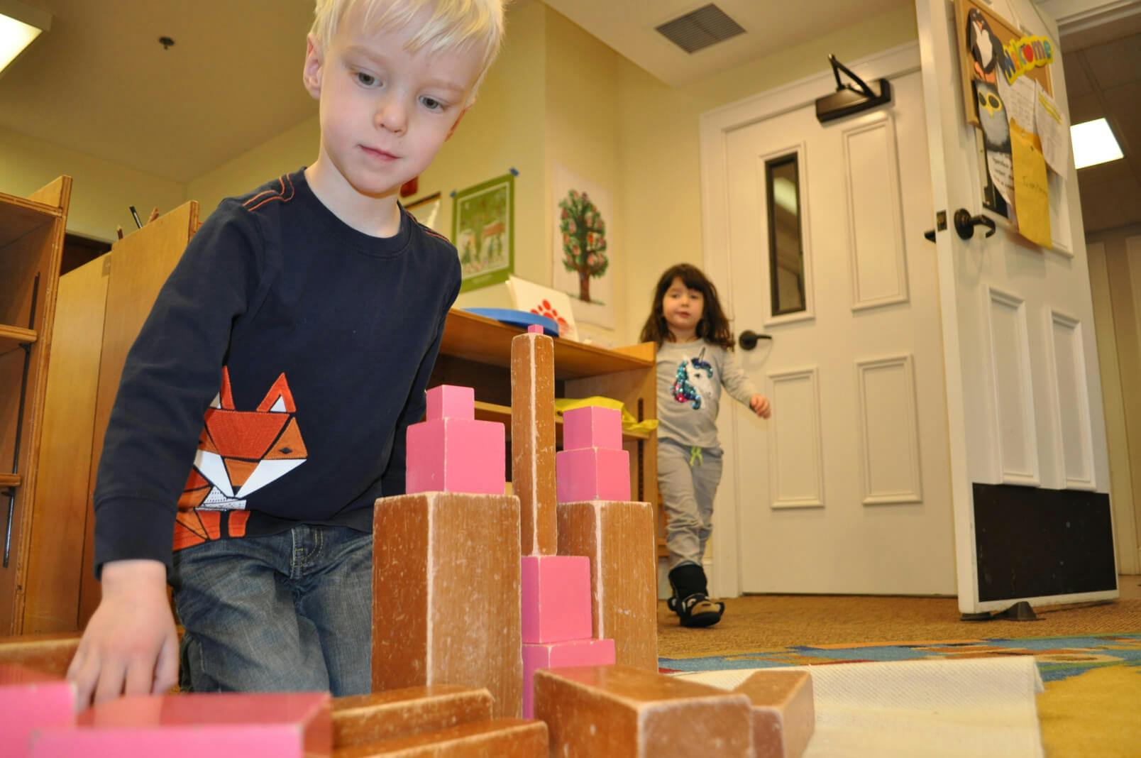 Child building with blocks, another child in background