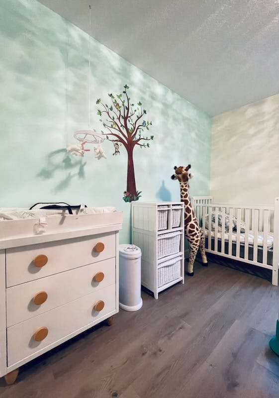 Nursery room with a changing table, crib, and giraffe plush toy