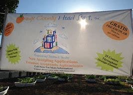 White banner with text and a logo under a bright sky