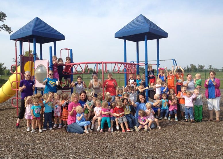 Group of adults and children posing on a playground
