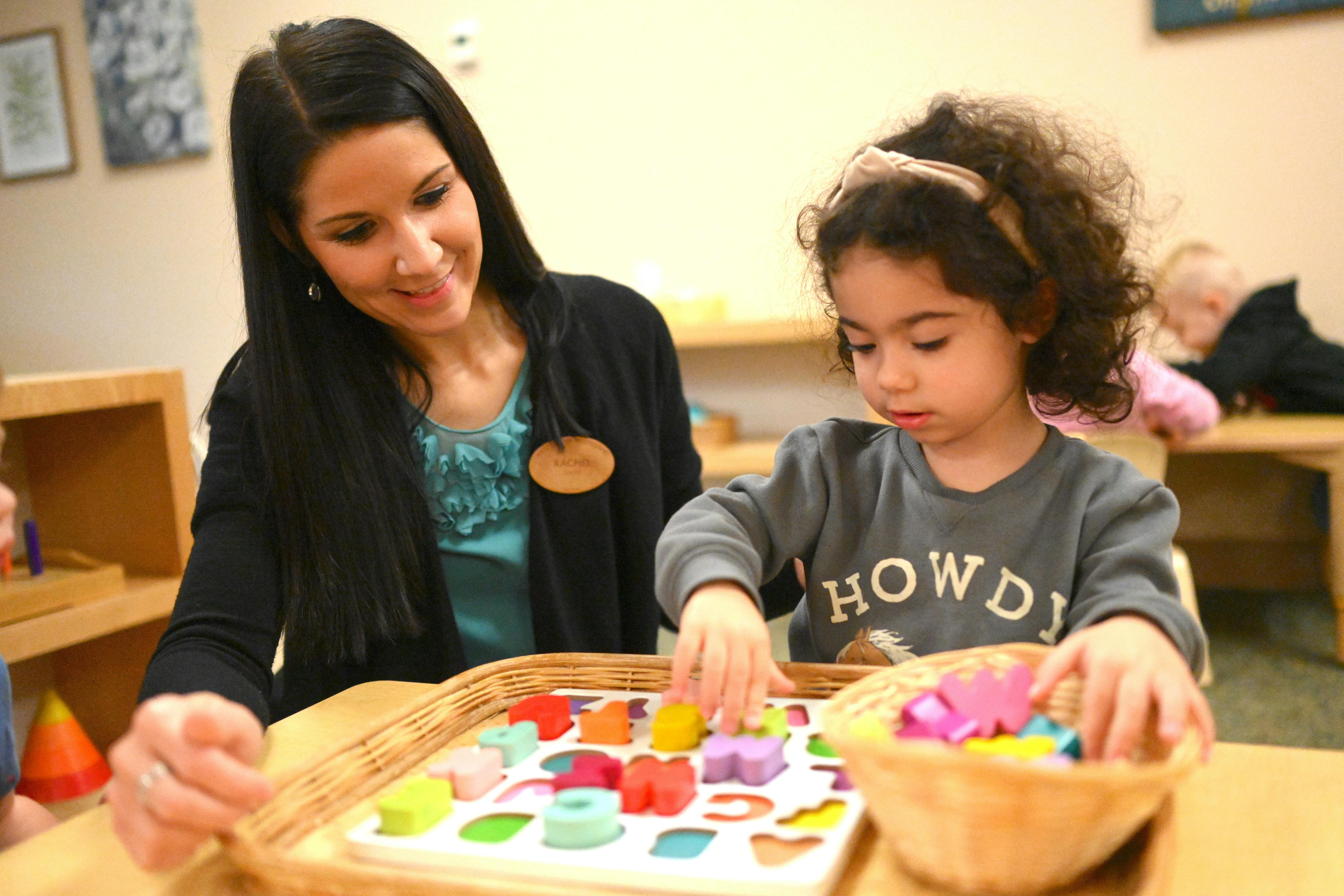 Adult and child playing with colorful shape sorter