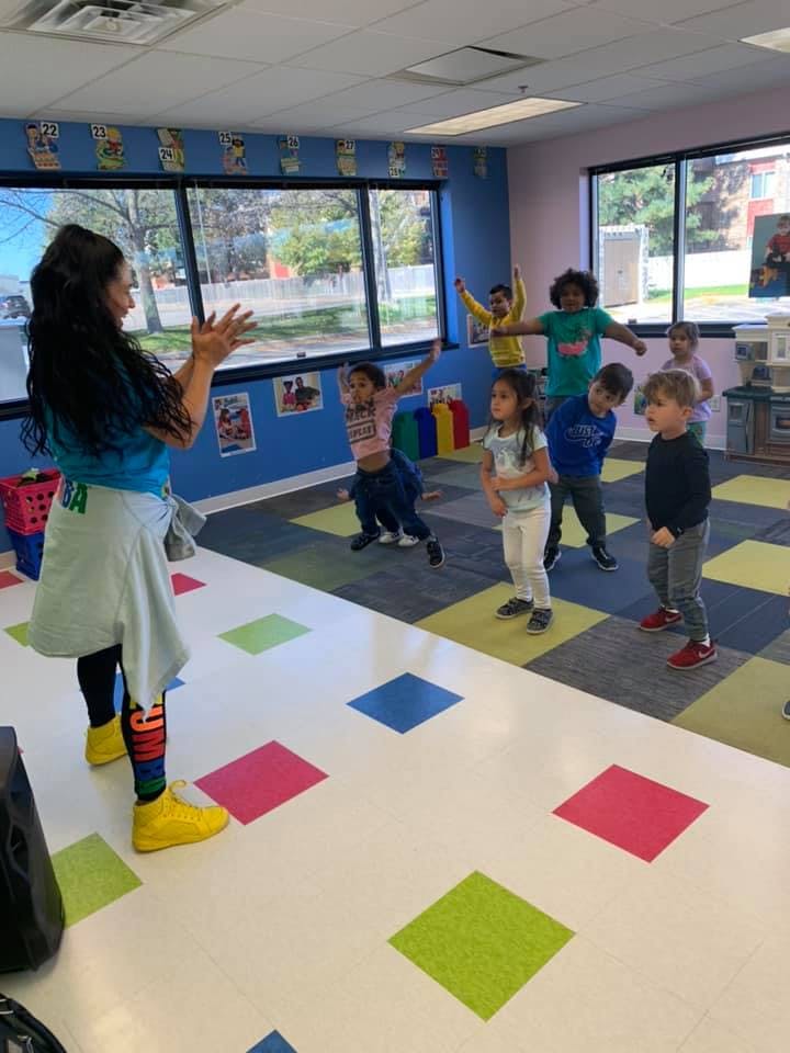 Person leading a group of children in an activity in a classroom